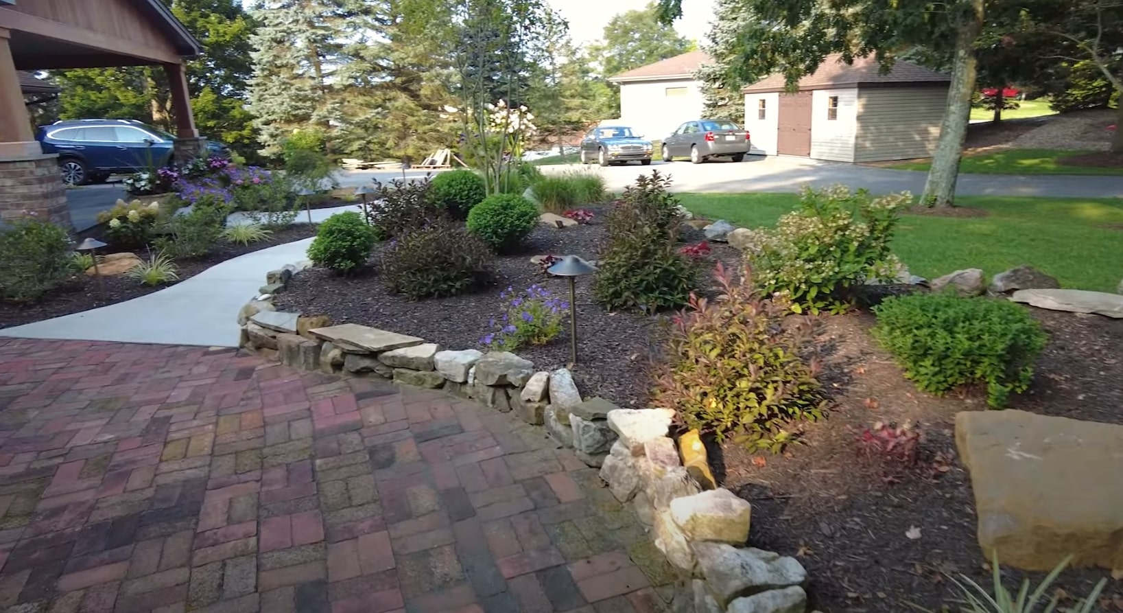 Front Yard Landscaping with Curved Stone Features Front yard landscaping with curved stone borders and mixed plantings
